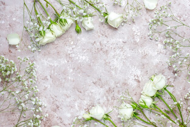 Tarjeta de primavera con rosas blancas y flores, vista superior