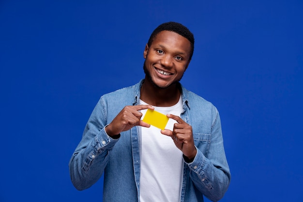 Foto gratuita tarjeta de tenencia de hombre sonriente de tiro medio