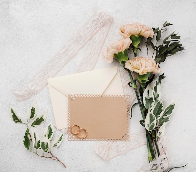 Foto gratuita tarjetas de invitación de boda con flores sobre la mesa