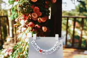 Foto gratuita las tarjetas con letras 'just married' cuelgan en el soporte gris afuera