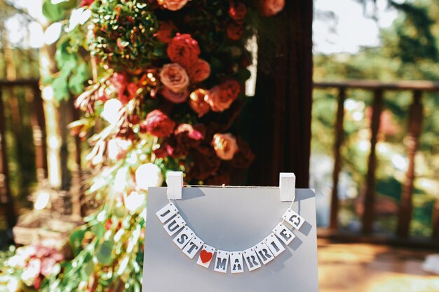 Las tarjetas con letras &#39;Just Married&#39; cuelgan en el soporte gris afuera