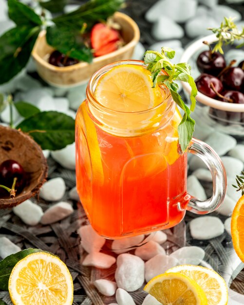 Un tarro de albañil con cóctel de naranja con rodajas de naranja