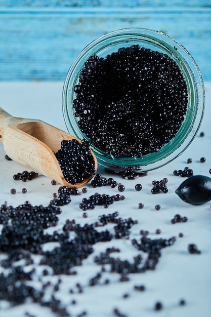 Un tarro de caviar en una pared azul.