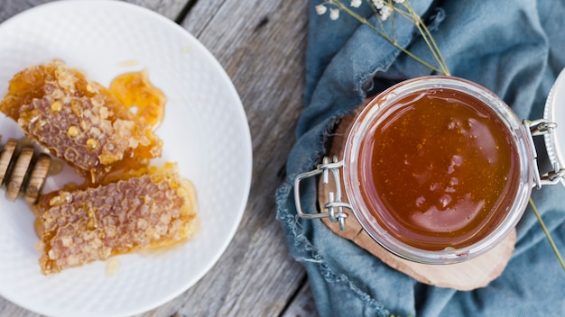 Tarro de cristal lleno de miel con cuchara de miel