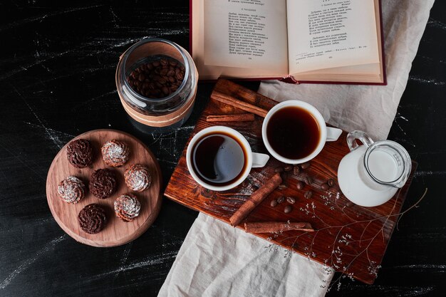 Tarro de leche con tazas de café y galletas