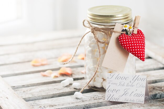 Tarro con malvaviscos y un corazón enganchado con una pinza