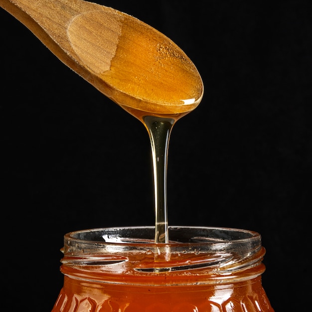 Tarro de miel con cuchara de madera