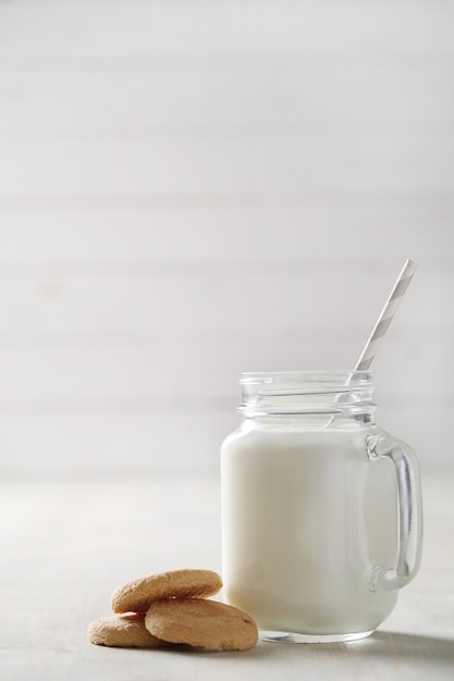 Tarros de leche y galletas en la mesa de madera