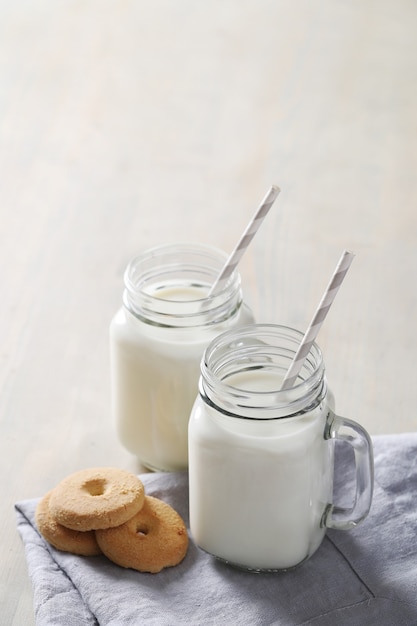 Tarros de leche y galletas en la mesa de madera