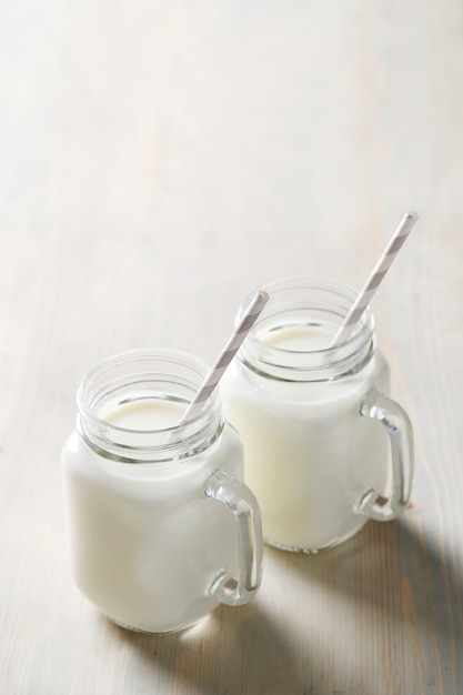 Foto gratuita tarros de leche en mesa de madera