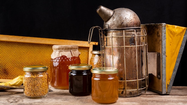 Tarros de miel con ahumador de abejas y panal