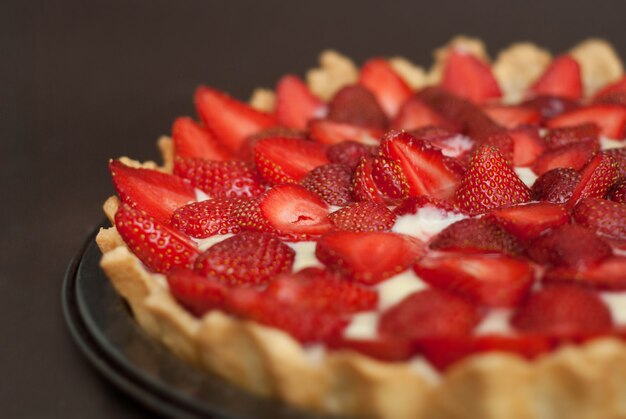 Tarta casera de fresa sobre fondo oscuro.