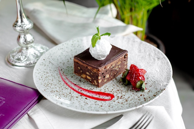 Tarta de chocolate con nueces, helado encima y fresas