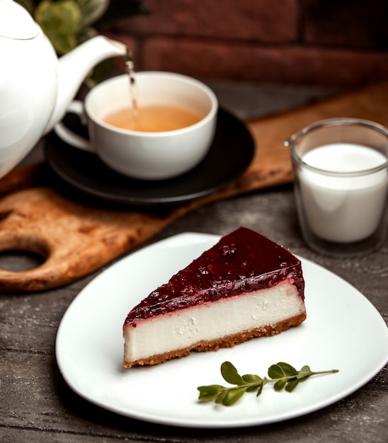 Tarta clásica de queso de bayas y una taza de té caliente