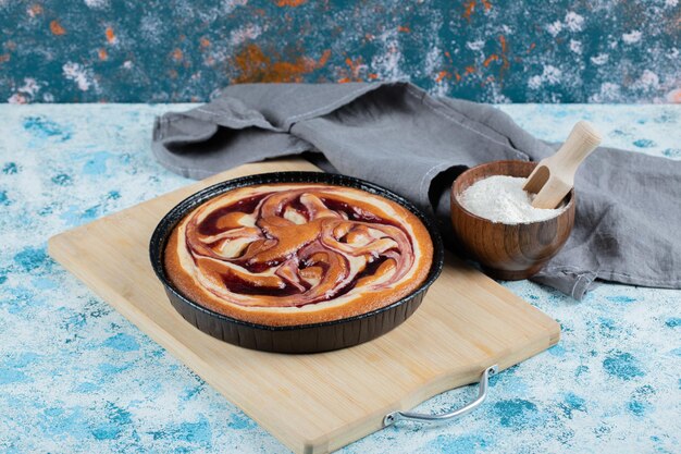 Tarta de fresa en bandeja metálica negra.