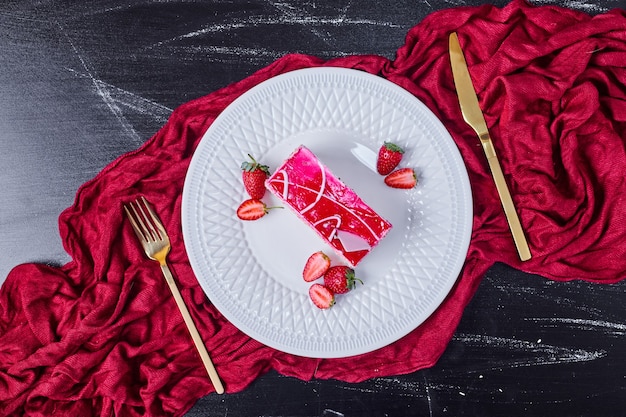 Foto gratuita tarta de fresa con cubiertos de oro sobre plato blanco.