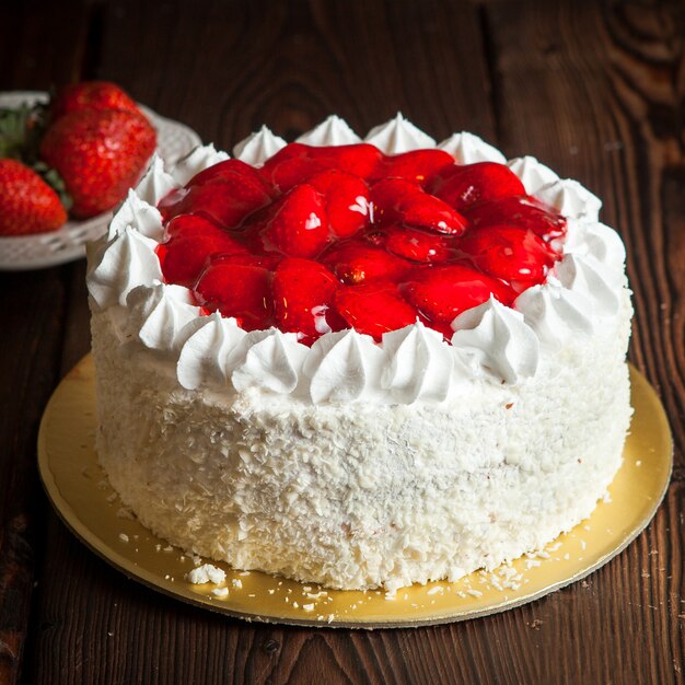 Tarta de fresas y fresas frescas en la mesa de madera