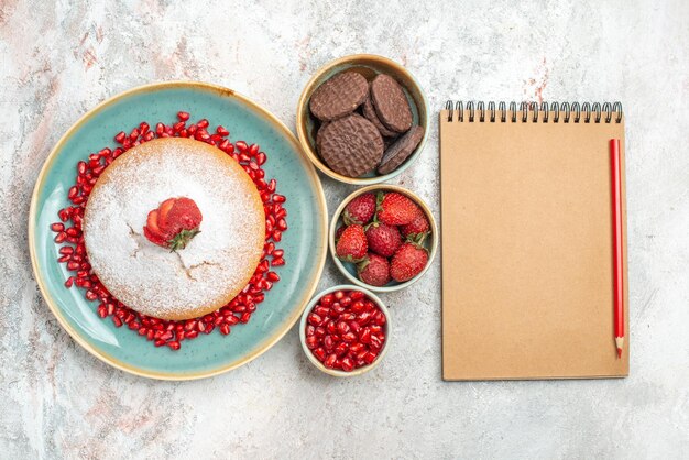 tarta con fresas tarta con fresas junto al cuaderno y bolígrafo