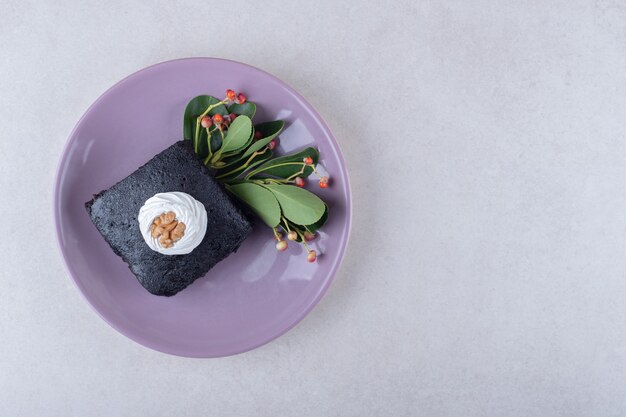 Tarta de frutos rojos con brownies con nuez en plato, sobre el mármol.