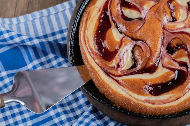 Tarta de jarabe de fresa en bandeja metálica negra.