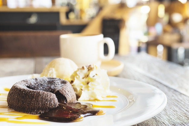 Tarta de lava de chocolate en un plato blanco con una taza de café en la cafetería