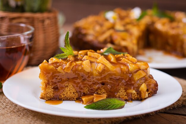 Tarta de manzana con salsa de caramelo sobre un fondo de madera