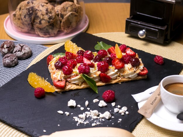 Tarta de Napoleón con crema de frambuesa naranja malvaviscos cereza vista lateral de menta