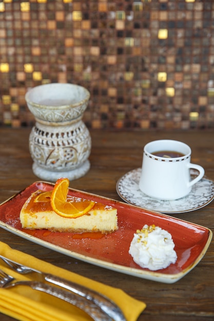 Tarta de queso con crema de naranja, servida con té