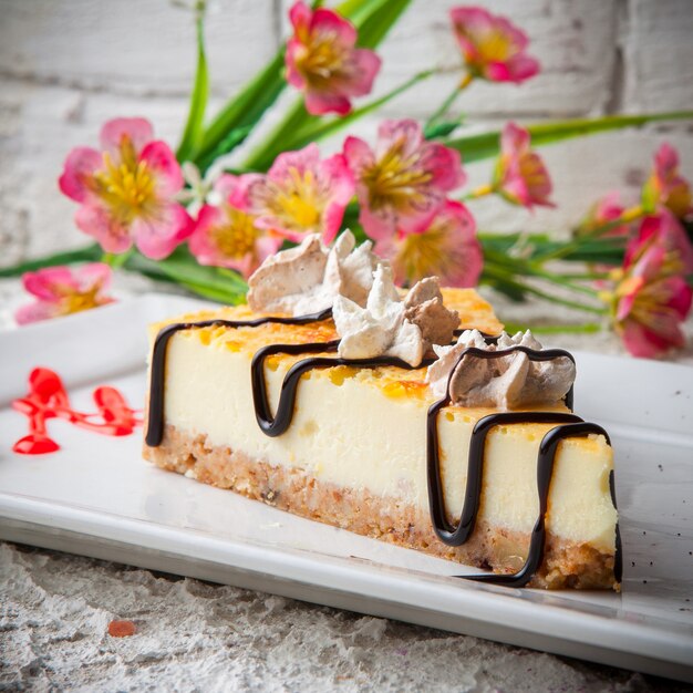 tarta de queso con flores en plato blanco