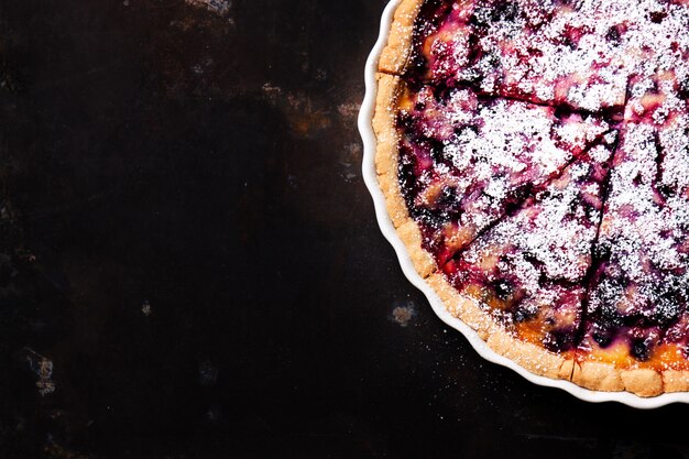 Tarta de queso con frambuesa en una mesa de madera oscura