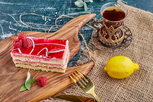 Tarta de queso de fresa con un vaso de té.