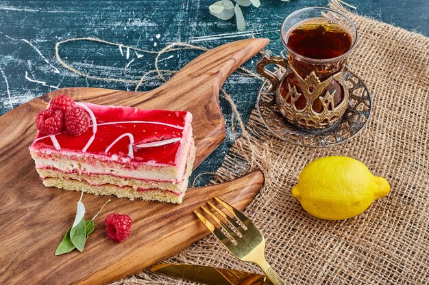 Tarta de queso de fresa con un vaso de té.