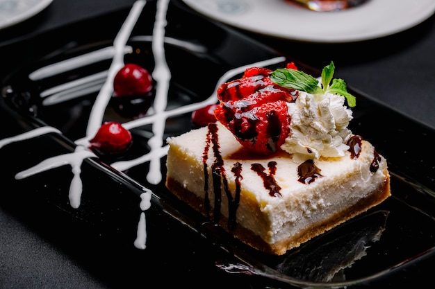 Tarta de queso con mermelada de crema de fresa cereza vista lateral