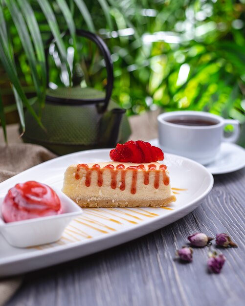 Tarta de queso con mermelada de frutilla y helado vista lateral