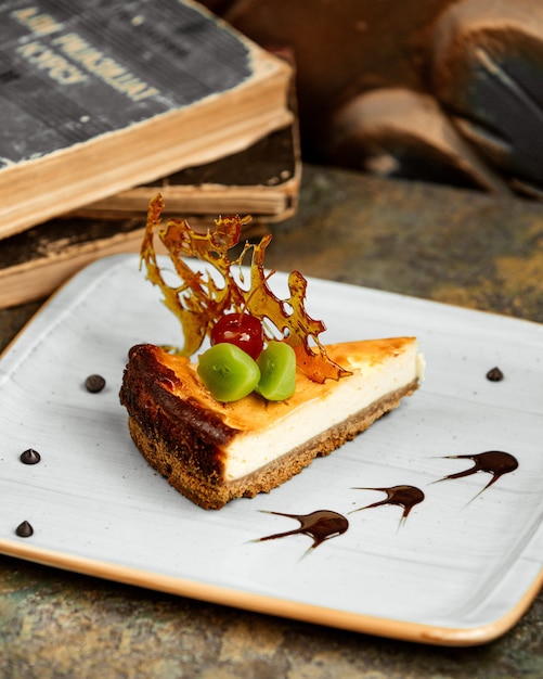 tarta de queso con rodaja de cereza glaseada con kiwi y azúcar caramelizada