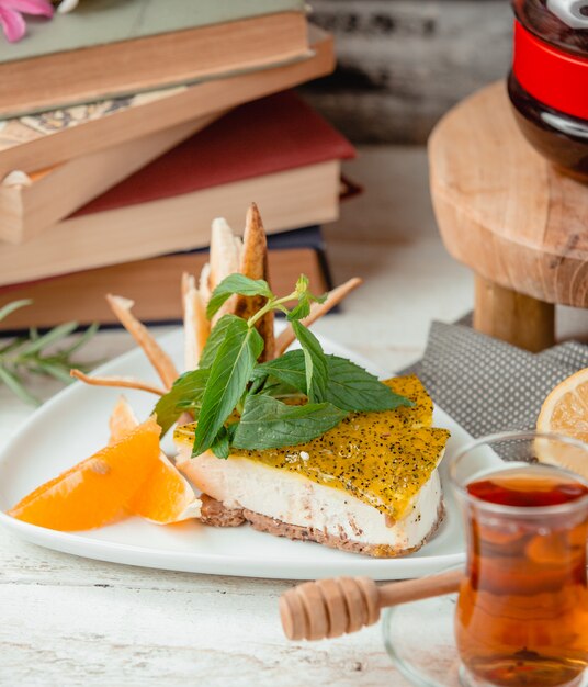 Tarta de queso con rodaja de naranja sobre la mesa
