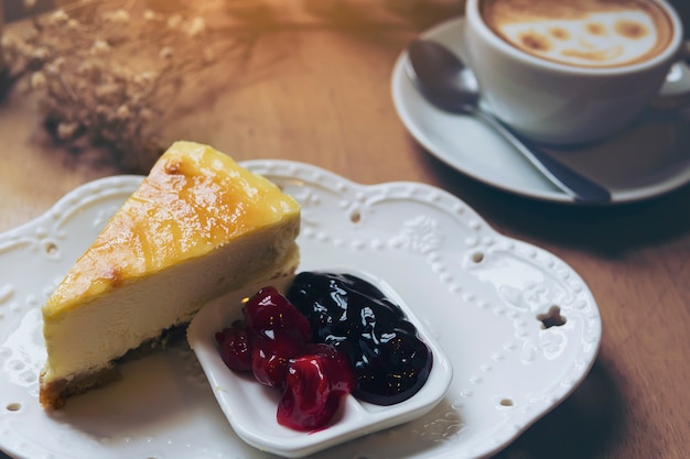 Foto gratuita tarta de queso con taza de café caliente en mesa de madera