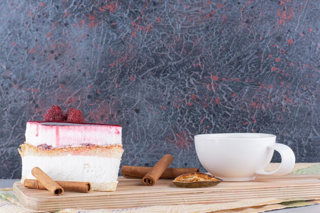 Tarta de queso y taza de té negro sobre tabla de madera. Foto de alta calidad