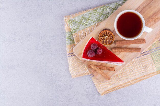 Tarta de queso y taza de té negro sobre tabla de madera. Foto de alta calidad