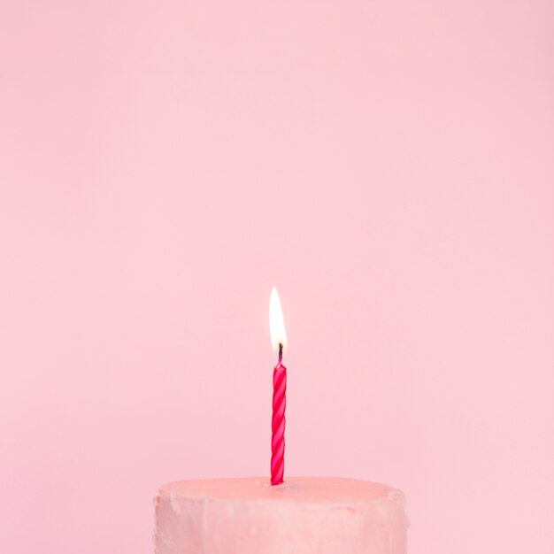 Tarta rosa con vela encendida