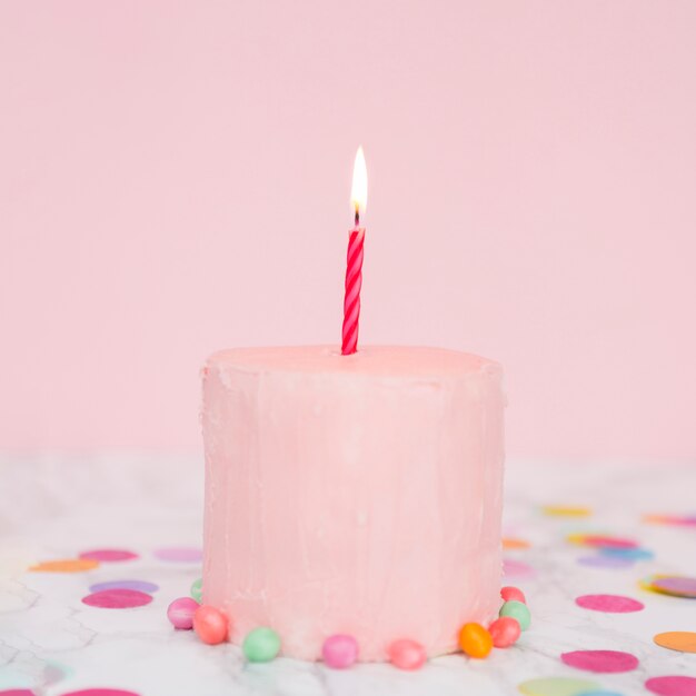 Tarta rosa con vela encendida