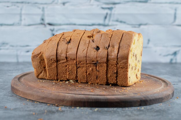 Tarta de sultana en rodajas sobre una tabla de madera rústica.