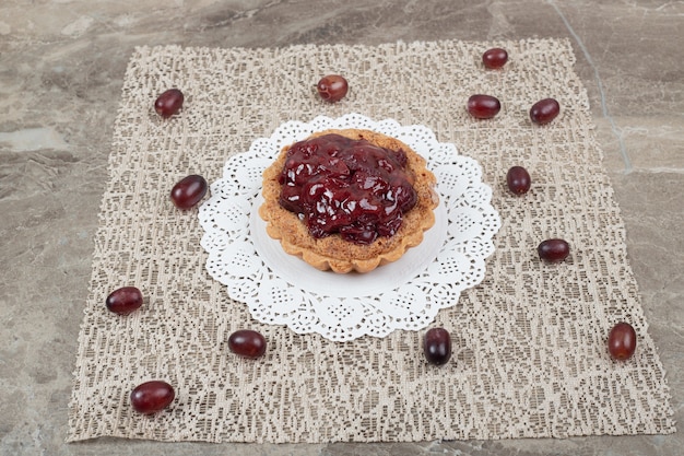 Tarta de tarta con frutas sobre arpillera y uvas.