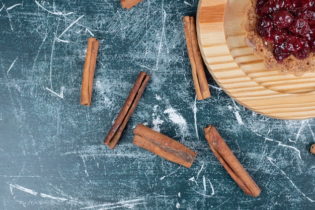 Tarta de tarta en placa de madera con canela en rama. Foto de alta calidad