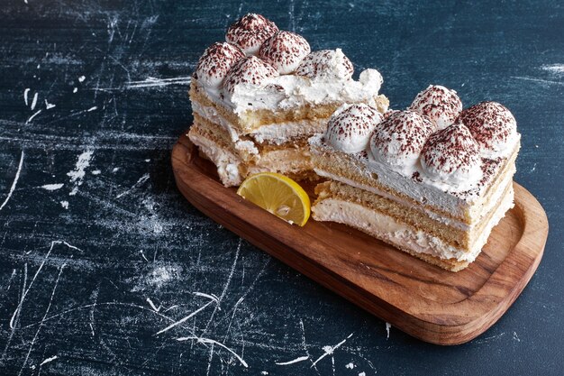 Tarta de tiramisú en rodajas en bandeja de madera.