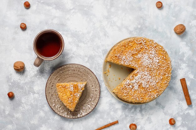 Tarta de zanahoria con velas 2020 y una taza de té sobre hormigón gris