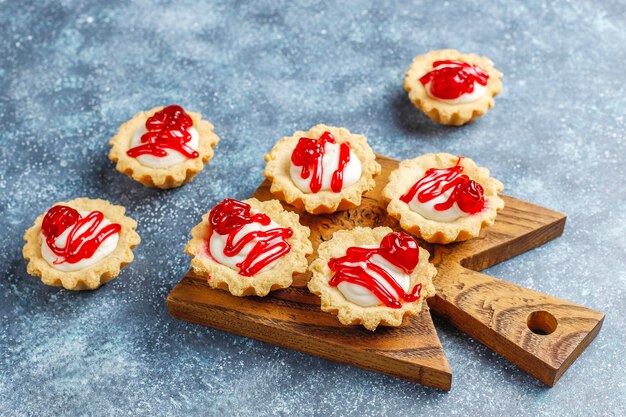 Tartaletas con relleno de chocolate blanco y mermelada de frutos rojos encima.