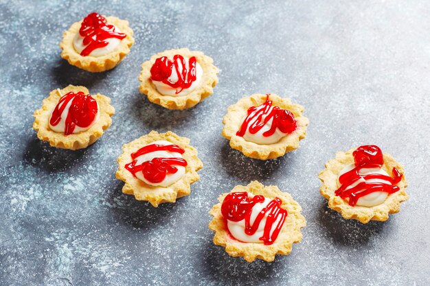 Tartaletas con relleno de chocolate blanco y mermelada de frutos rojos encima.