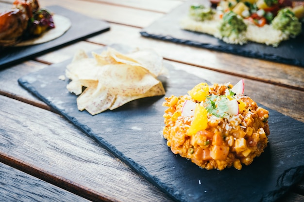 Tartar de carne de salmón fresco crudo en placa negra