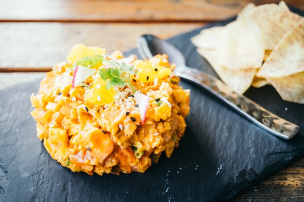 Tartar de carne de salmón fresco crudo en placa negra